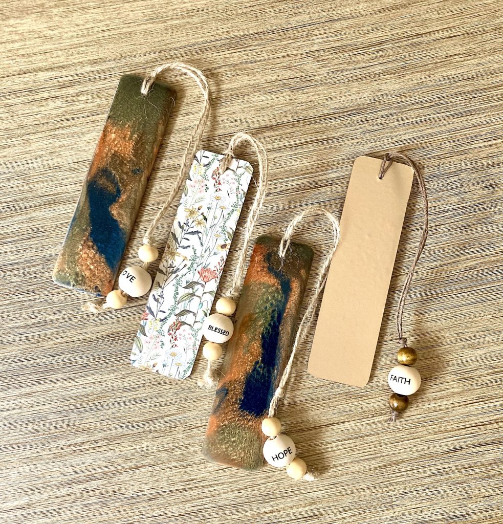 Wooden bookmark with campfire night resin hues, twine, and beads.