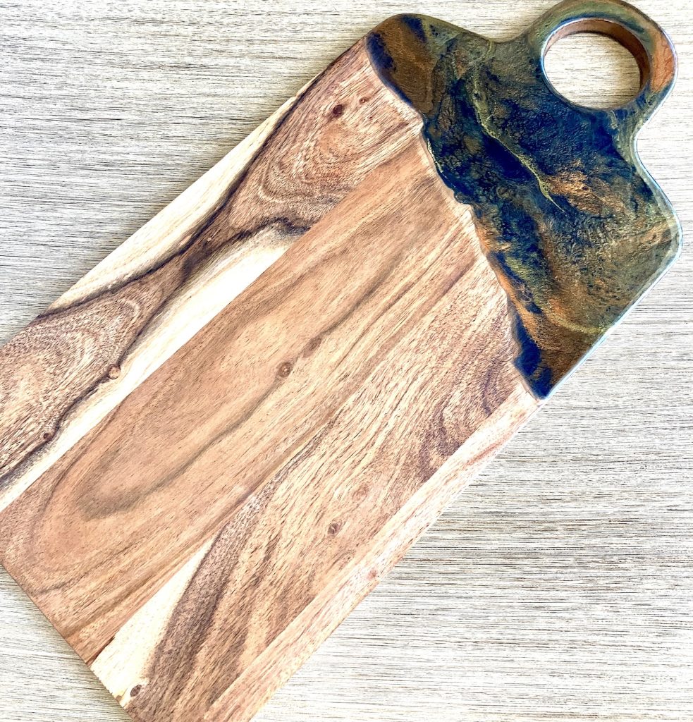 Rectangular acacia charcuterie board with resin coating inspired by the dancing embers in a campfire.