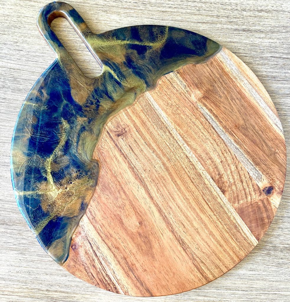 Round acacia charcuterie board with resin coating inspired by the dancing embers in a campfire.