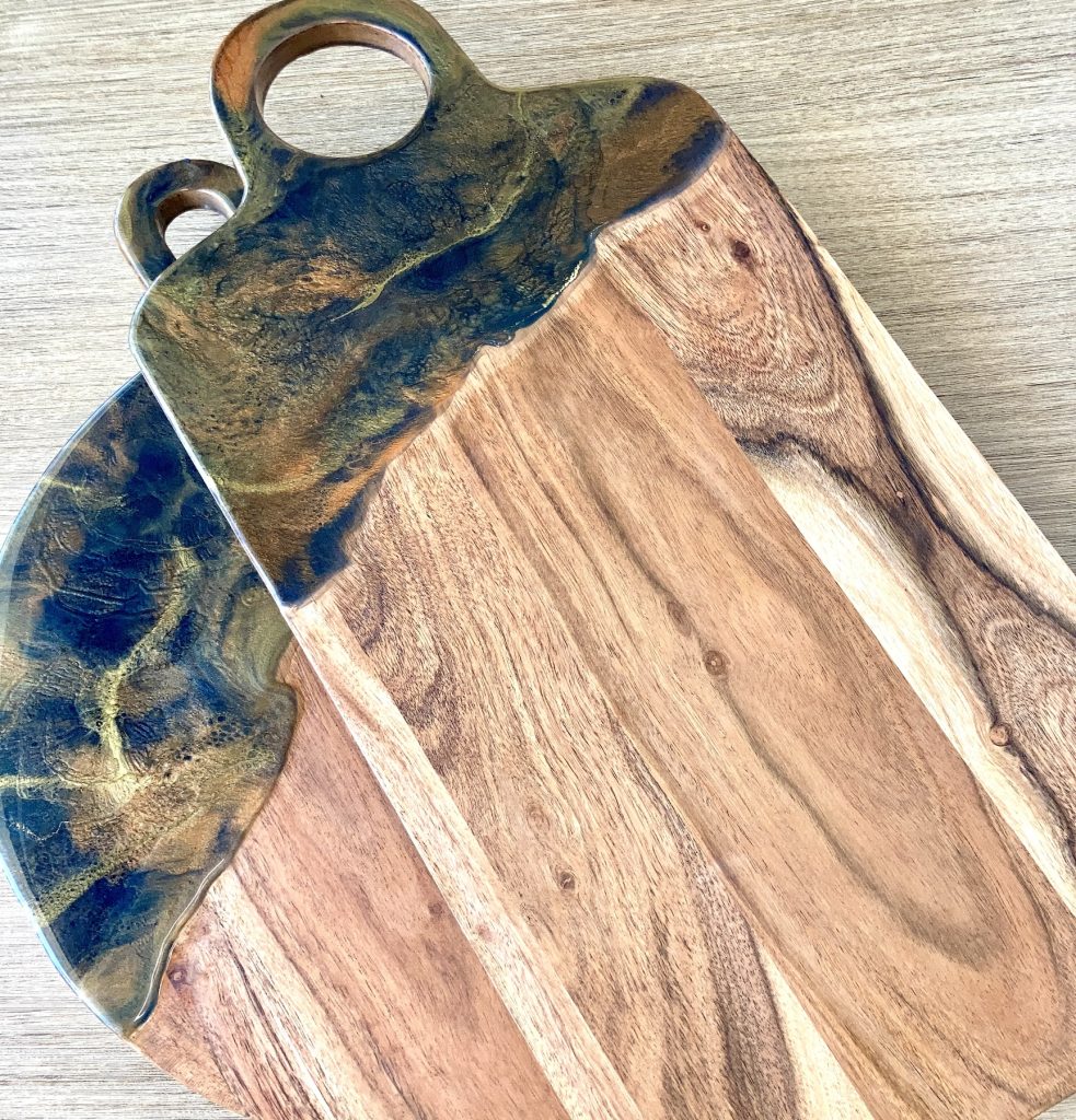 Two acacia charcuterie boards with resin coating inspired by the dancing embers in a campfire.